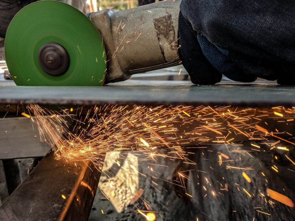 Crafting Captivating Headlines: Your awesome post title goes here Close-up of a worker using a grinder, creating sparks in a metal workshop environment.